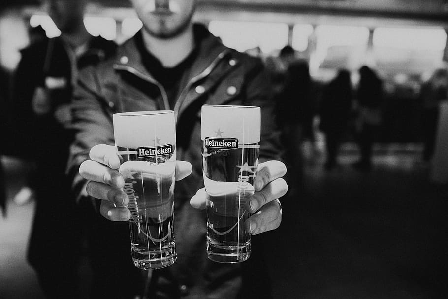 Cheers For Two, man holding two Heineken beer glasses, black and white