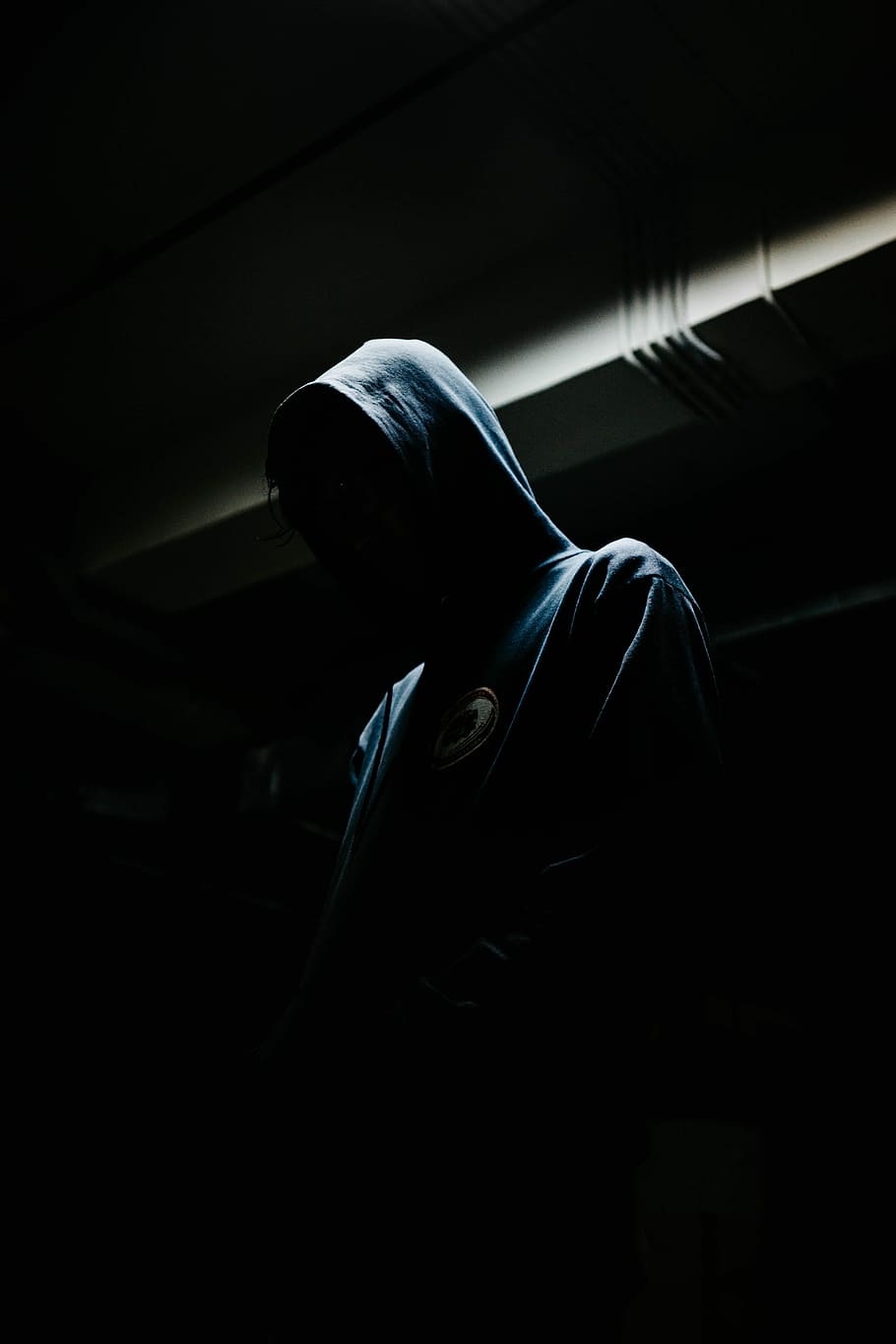 person in black hoodie, person wearing pullover hoodie, night