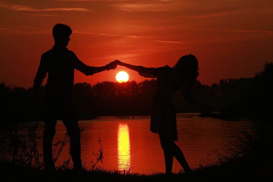 silhouette of man and woman dancing during sunset photo, couple