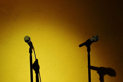 two black corded microphone with stands beside yellow painted wall HD wallpaper