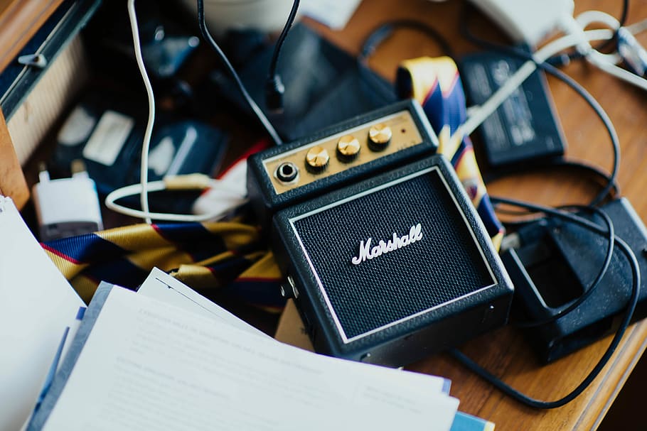 shallow focus photography of Marshall guitar amplifier, black Marshall MP3 player on desk