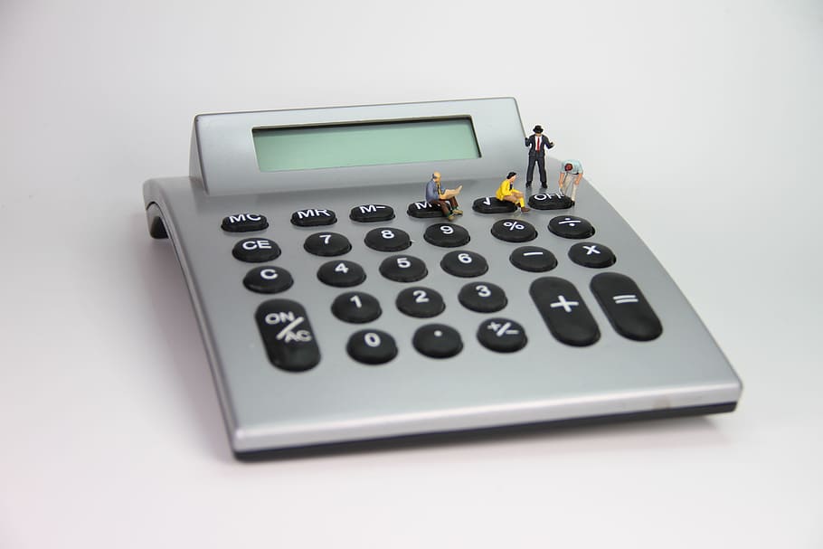 four figurines on turned off calculator, number, miniature figures