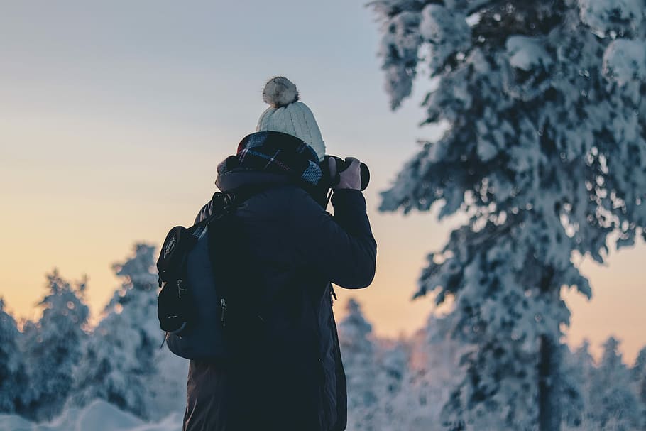 person in black winter jacket holding black DSLR camera during daytime, person taking photo using DSLR camera HD wallpaper