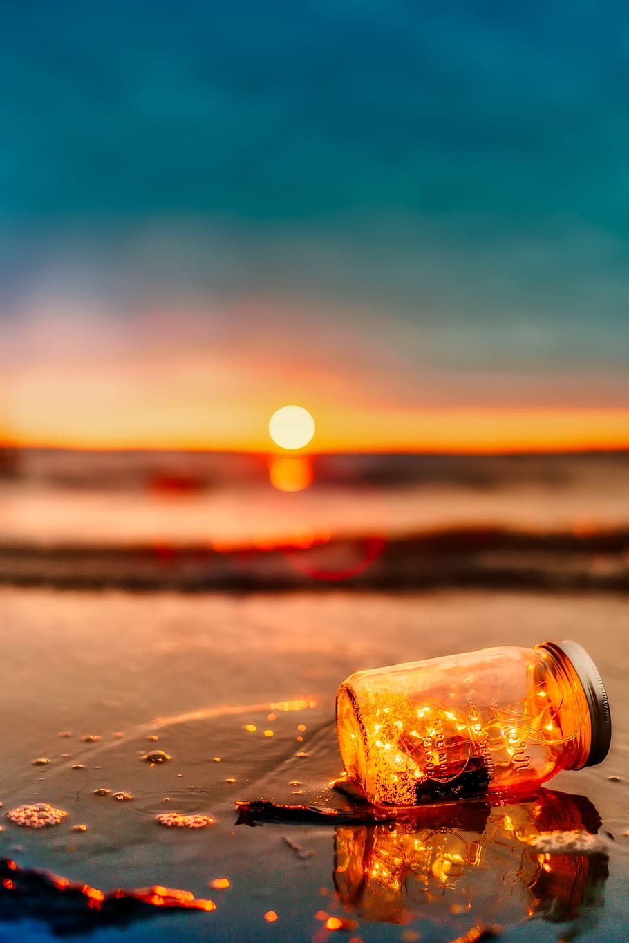 brown bottle on seashore during golden hour, sunset, dusk, ocean