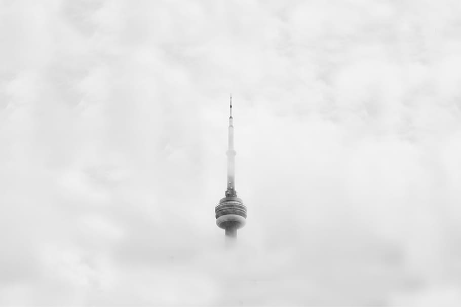 CNN Tower in Canada surrounded by clouds, grayscale photo of tower