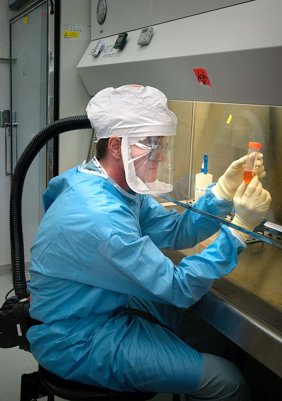 man in blue overalls and beige gloves, microbiologist, scientist