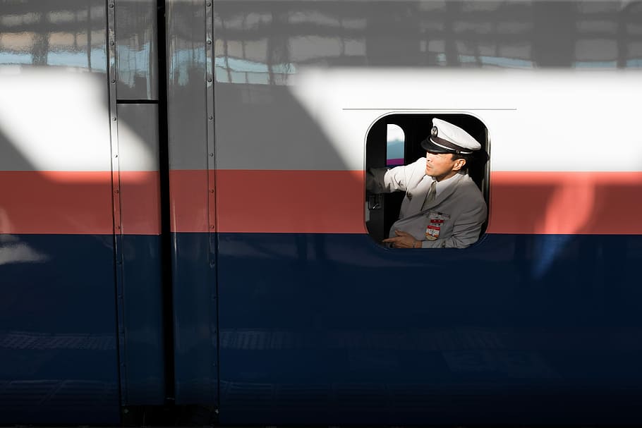 pilot sitting to opened window, man wearing grey jacket inside white, red, and blue train HD wallpaper