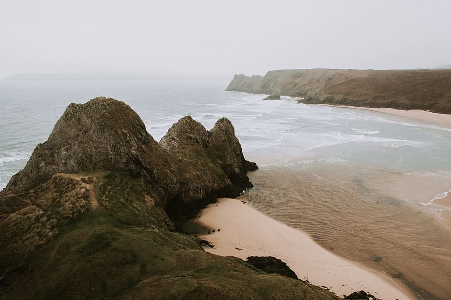 Three Cliffs, rock formation beside body of water during daytime HD wallpaper