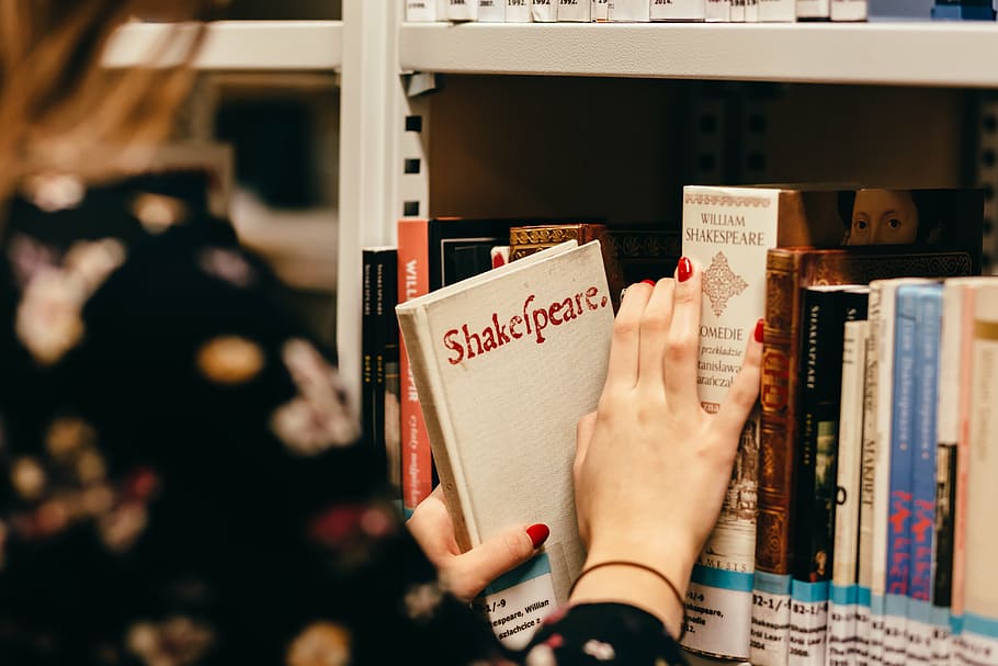 macro shot photography of woman in black top holding Shakespeare book HD wallpaper
