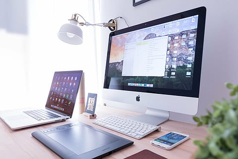 silver iMac and MacBook Air beside Amazon Kindle E-book reader on brown wooden desk HD wallpaper