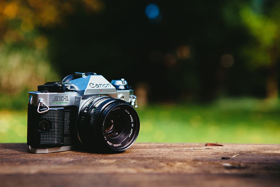 black and gray Canon DSLR camera on table, photography themes HD wallpaper