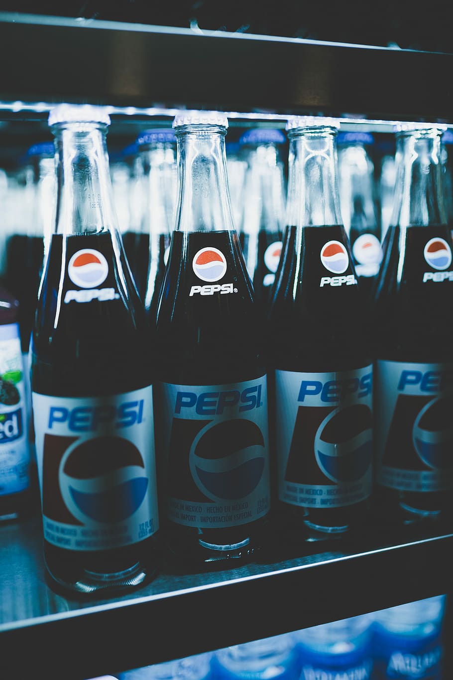 Pepsi bottles on cooler, close-up photo of Pepsi glass bottles