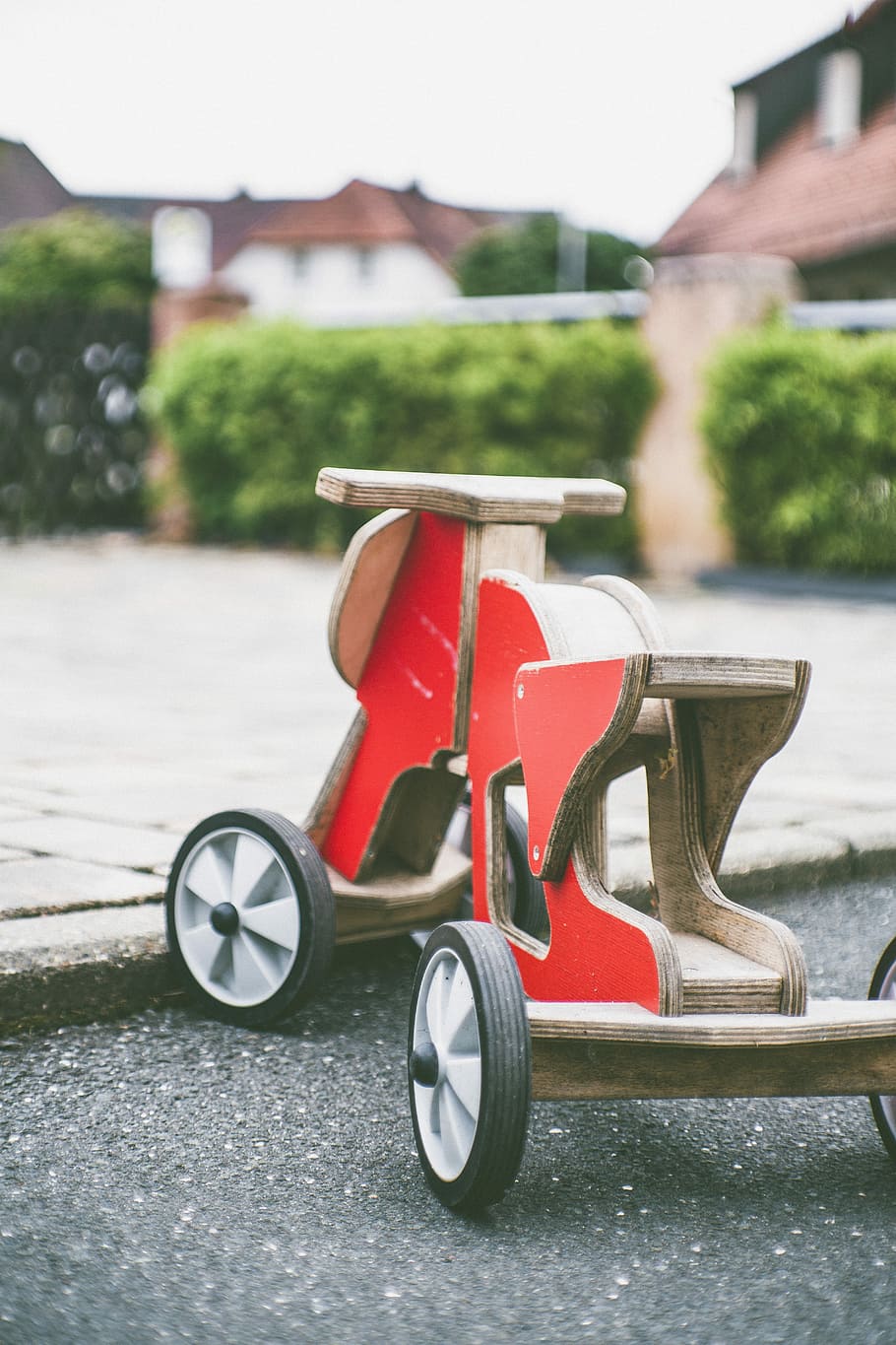 toddler's red and brown wooden ride-on toy on concrete pavement, phoot of red and brown wooden ride-on toy on gray surface, HD wallpaper