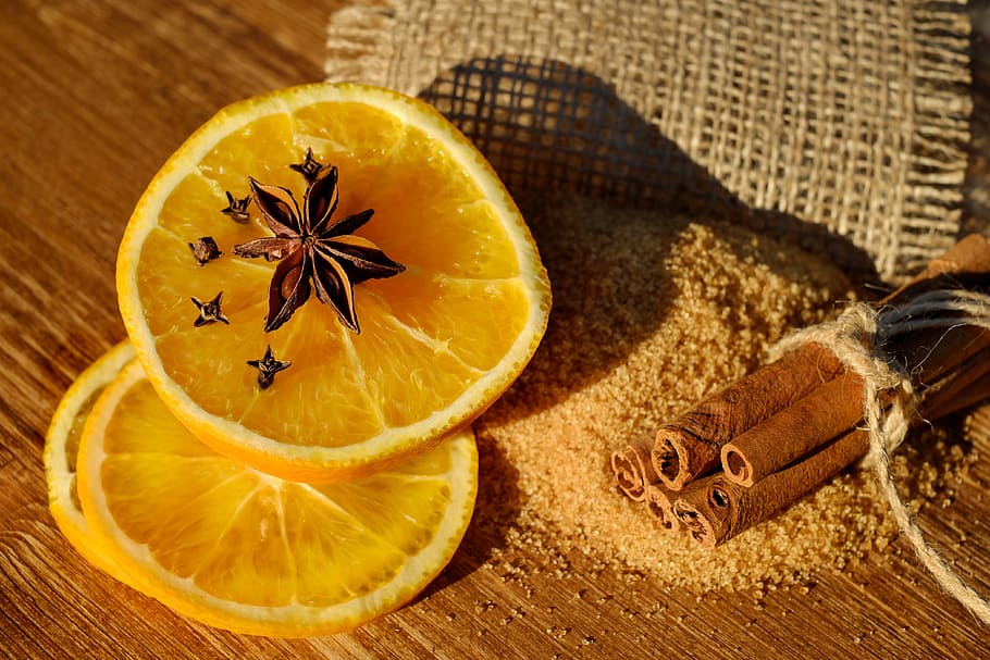 sliced orange fruit on brown surface, anise, star anise, seeds