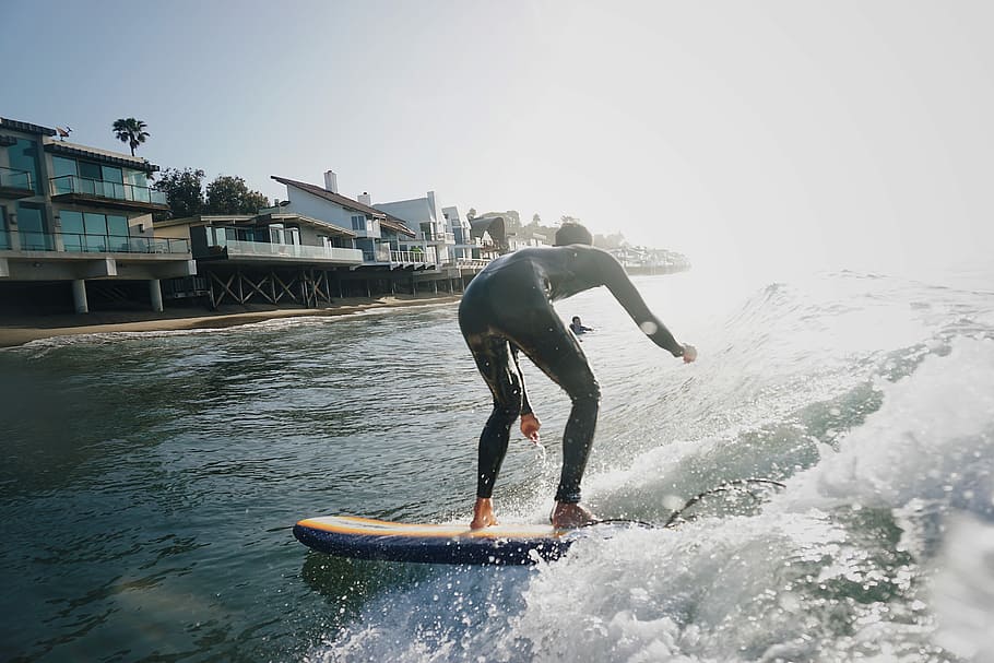 man on surfboard on body of water, man on white surfboard during daytime HD wallpaper