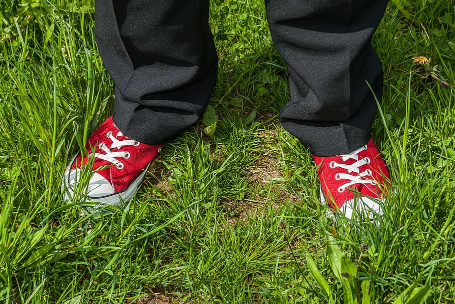 person standing on grass during daytime, red, red boots, white