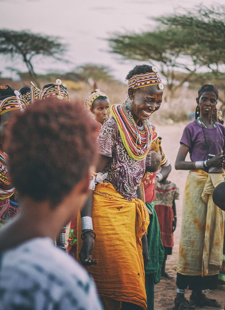 smiling woman dancing around people in tribe during daytime, tribal women macro shot, HD wallpaper