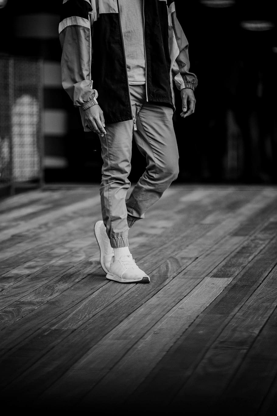grayscale photography of person standing on plank floor, black and white