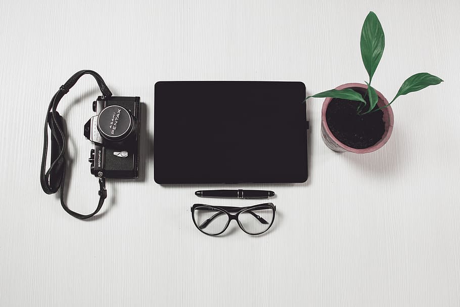 black tablet computer near camera, potted plant, twist pen, and black-framed eyeglasses, HD wallpaper