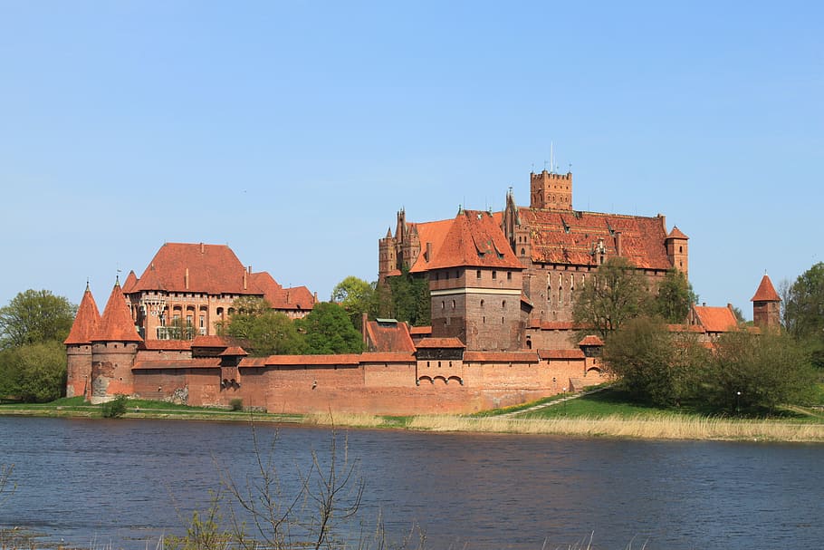photography of maroon concrete castle under blue sky at daytie HD wallpaper