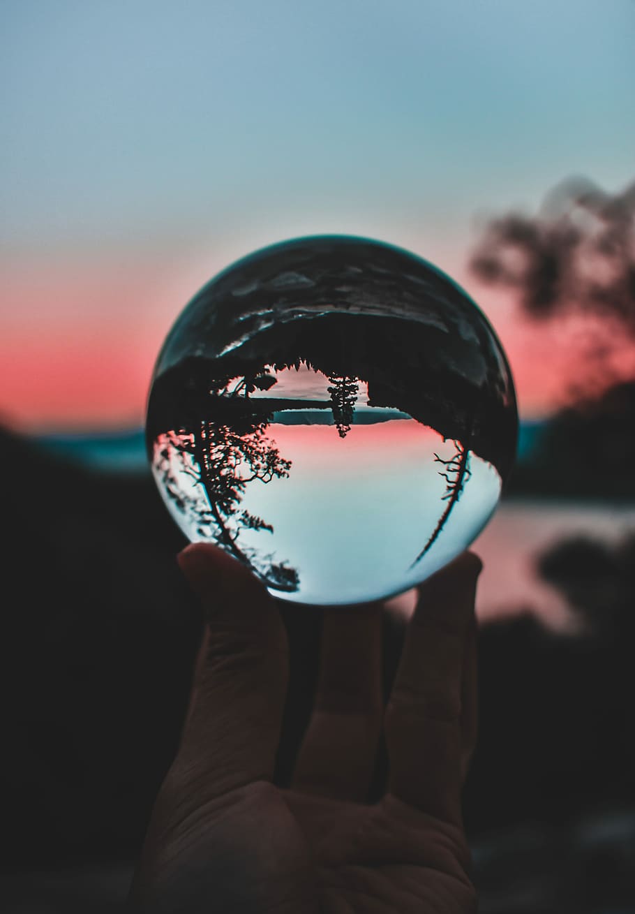 person holding clear crystal ball, tilt shift lens photography of clear ball HD wallpaper