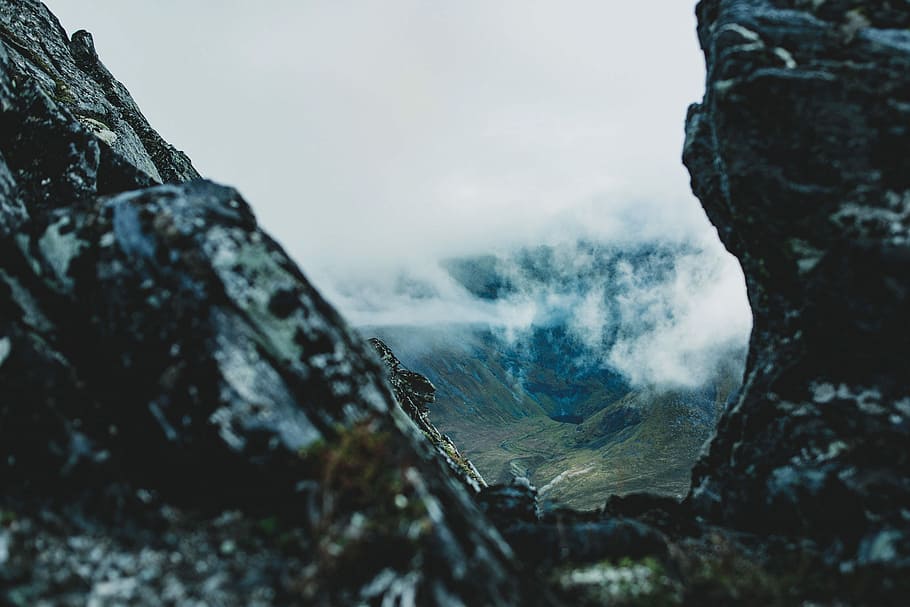rock formation under sea of clouds, shallow focus photography of rocky mountain HD wallpaper