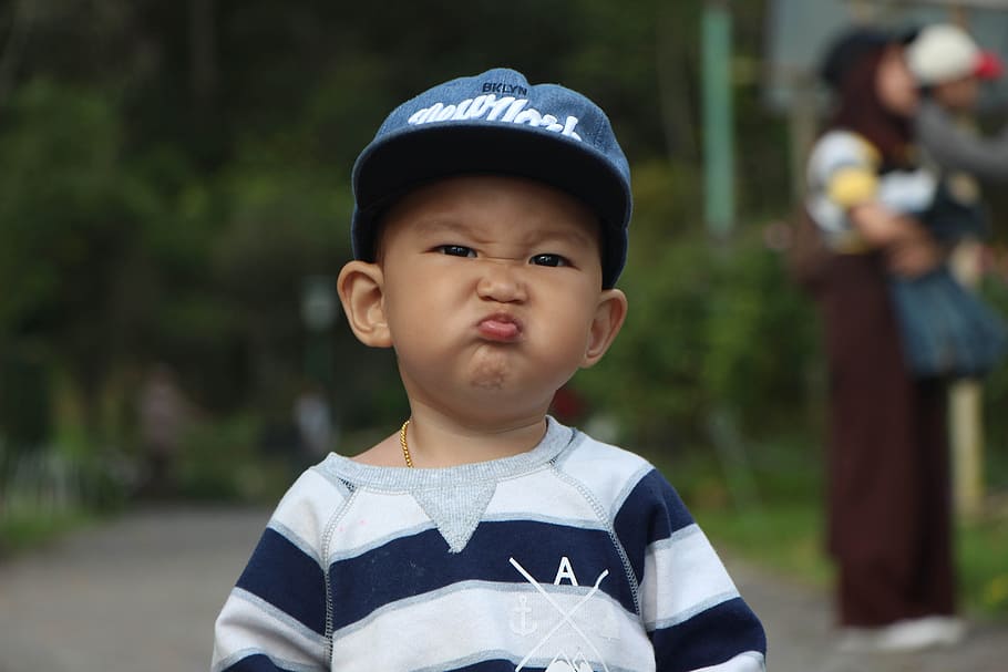 toddler in white and blue striped shirt with blue cap pouting, HD wallpaper