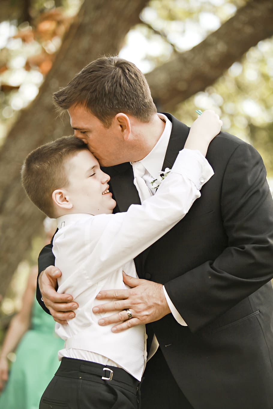 man kissing boy on forehead, groom, father, autism, son, wedding