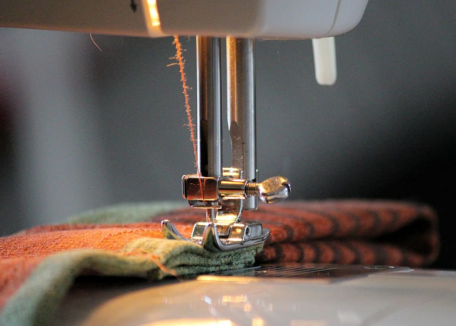 brown and green textile on sewing machine, foot, yarn, thread