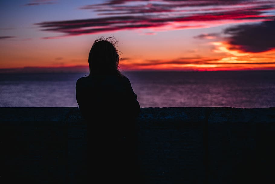 silhouette photo of person standing while looking at the ocean during golden hour, silhouette photography of person facing body of water HD wallpaper