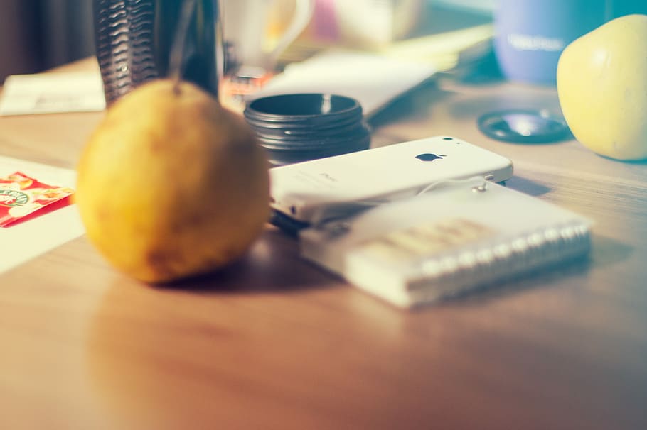 Morning workplace mood, white iPhone 5C and yellow fruit, pear