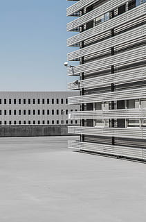 white and gray high-rise building under blue sky at daytime, low angle photography of concrete building HD wallpaper