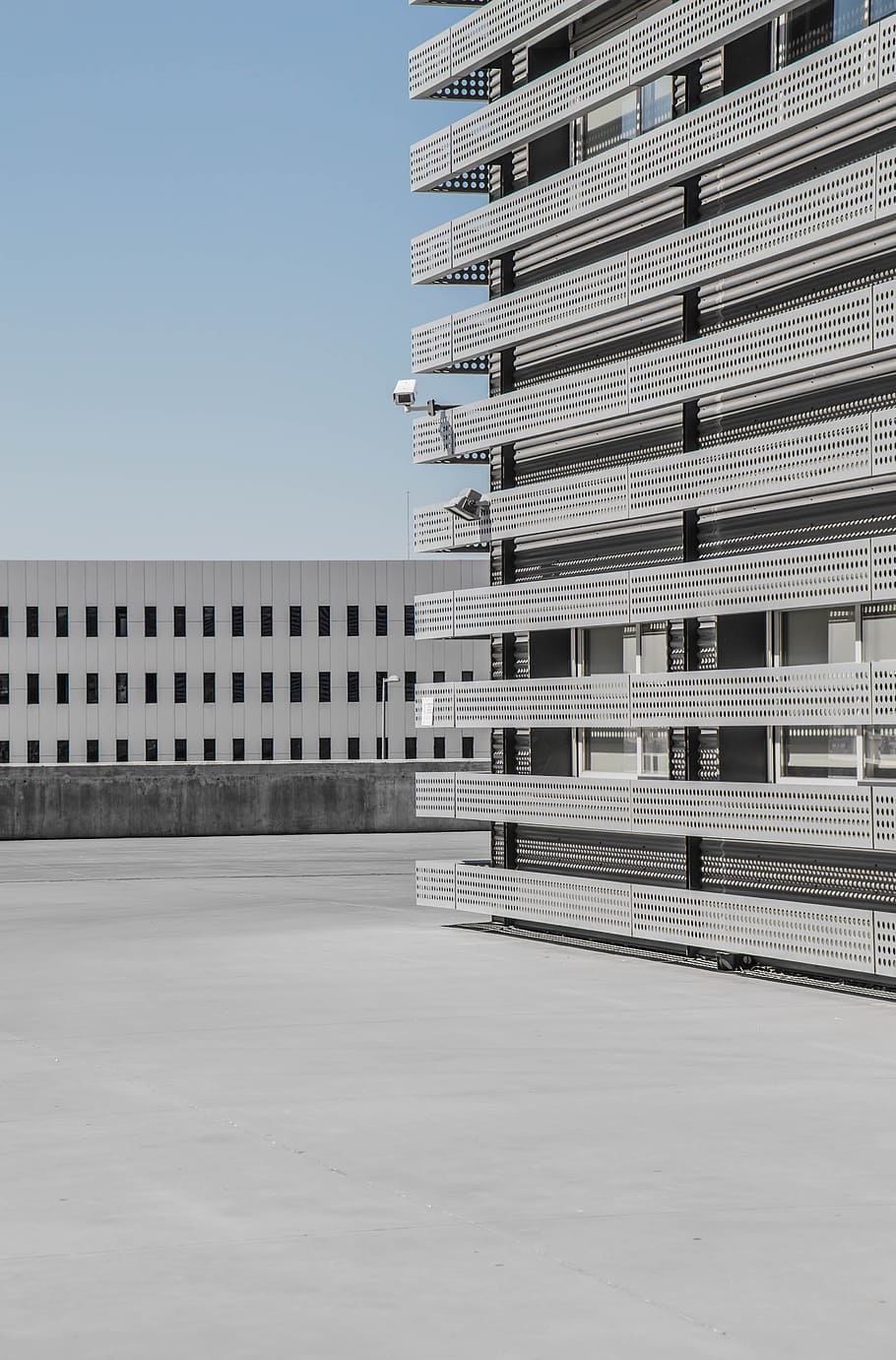 white and gray high-rise building under blue sky at daytime, low angle photography of concrete building HD wallpaper