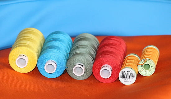 six assorted-color threads, sewing thread, bobbin, fabric, yellow HD wallpaper
