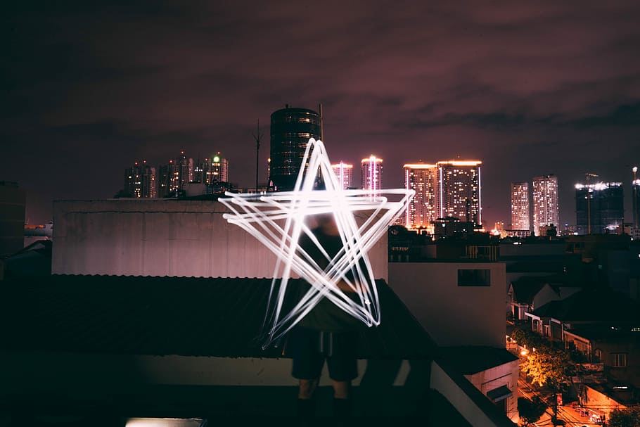 man holding star light, man standing on rooftop under black sky HD wallpaper