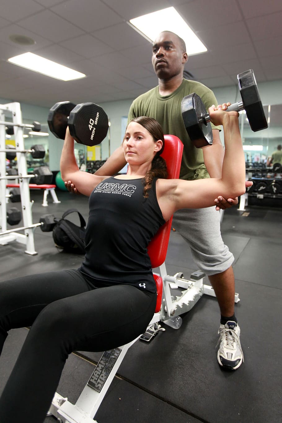 photo of man holding woman's biceps, weights, lifting, power
