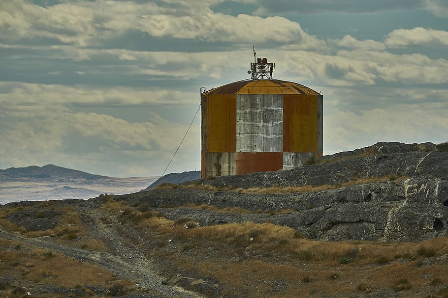 brown and gray tank near mountain, brown and grey silo on rock HD wallpaper