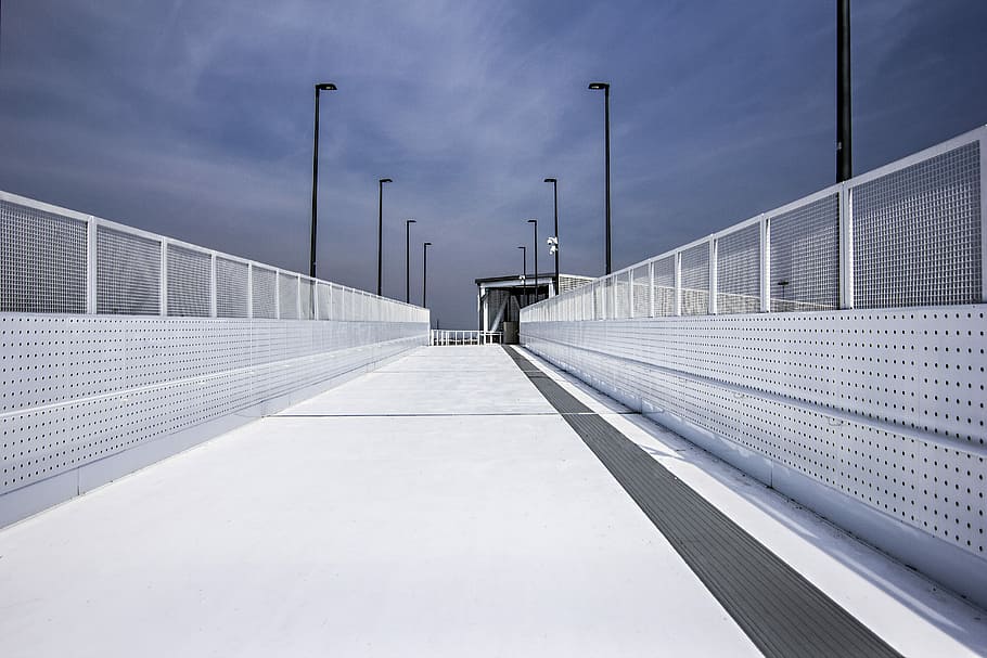 gray concrete floor between railings, pathway between white mesh fence HD wallpaper