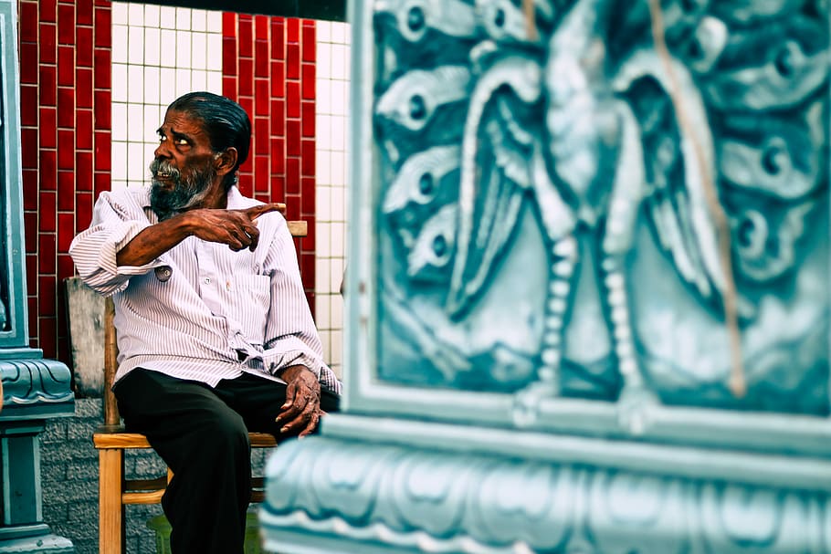 man sitting on chasir, man pointing at wall decor, building, architecture HD wallpaper