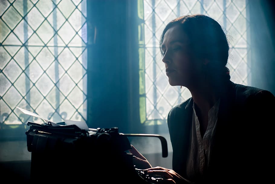 woman in black top looking into black typewriter, machine, to write HD wallpaper