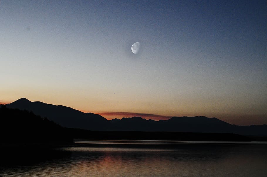 The Moon under sunshine, half moon over silhouette of mountains HD wallpaper