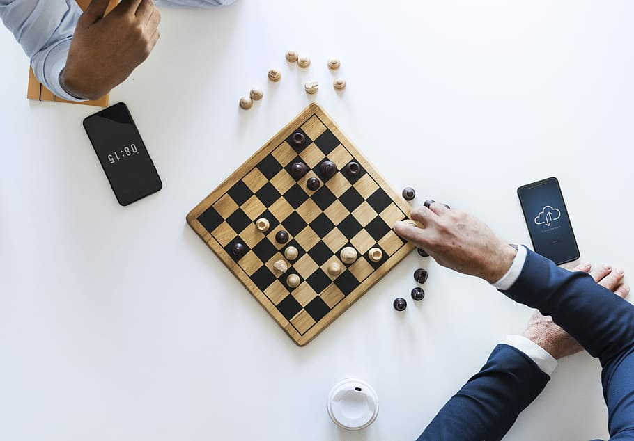 Download A Person Is Playing Chess On A Board Wallpaper