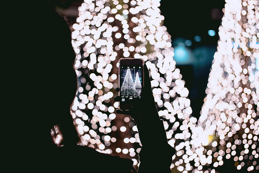 person taking picture of Christmas trees, person taking photo into lights HD wallpaper
