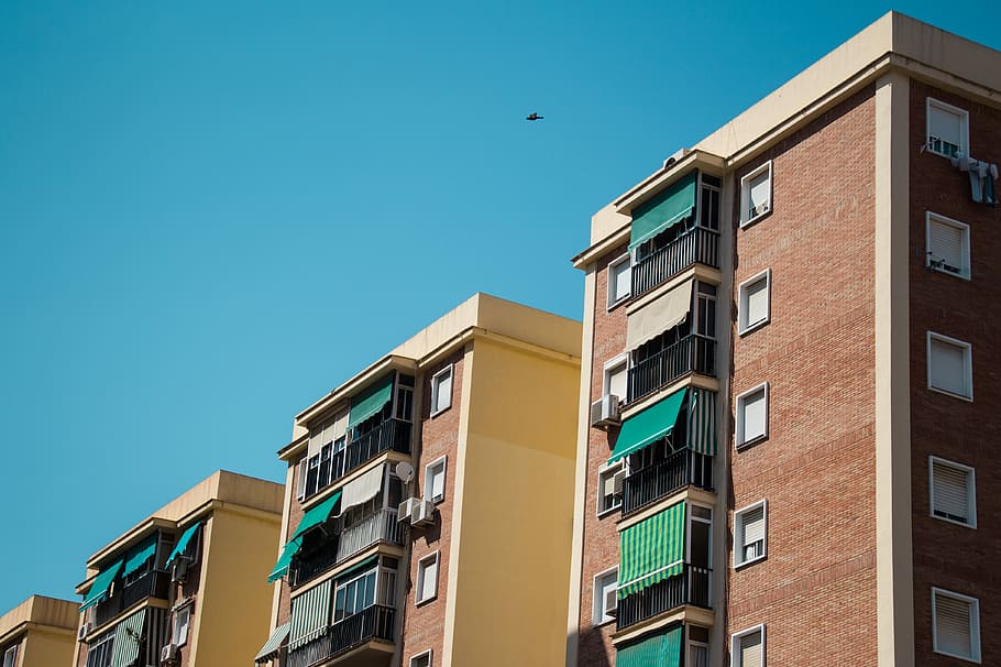 brown apartments under clear blue sky during daytime, brown and red condominiums during daytime HD wallpaper