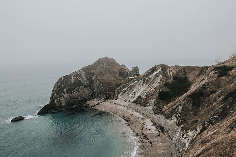 Durdle Door., body of water beside rocky mountain at daytime HD wallpaper