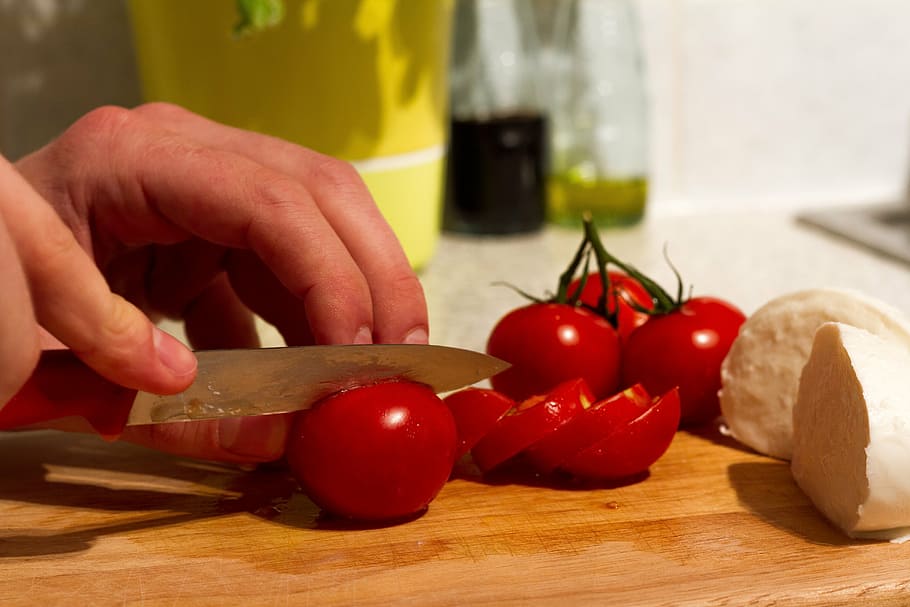 person slices red tomato on wooden chopping board, mozzarella HD wallpaper