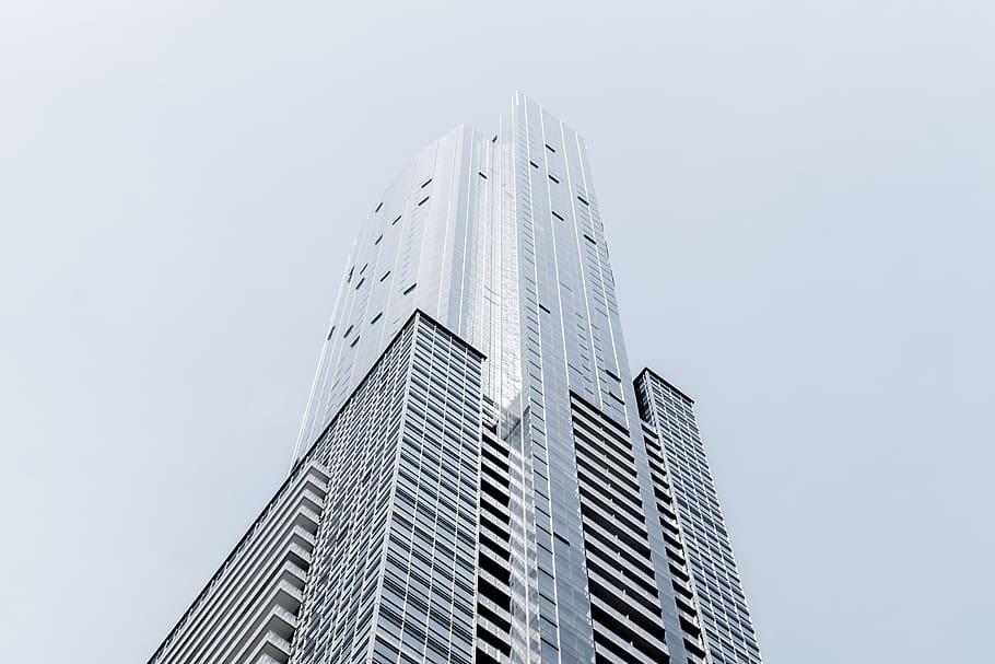 A tall skyscraper in Toronto against a pale blue sky, worms eye view of building HD wallpaper