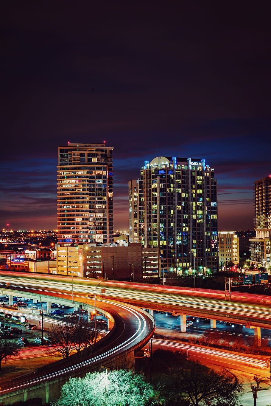 timelapse photography of red and orange light crossing on road near city during nighttime, time lapse photography of road beside high-rise building HD wallpaper
