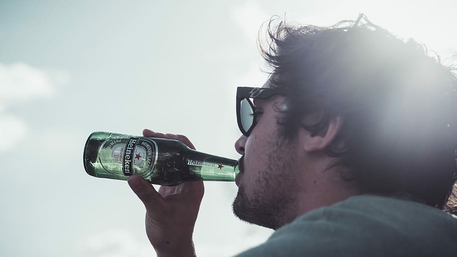 man drinking Heineken, sunny day, enjoying life, good time, drinking beer