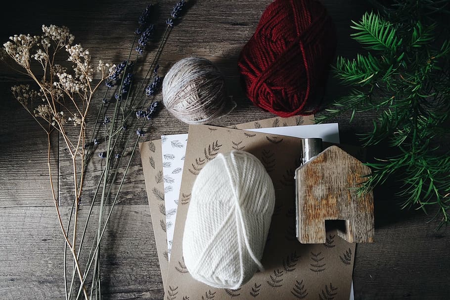 yarns on brown papers beside flowers on table, thread, knitting HD wallpaper